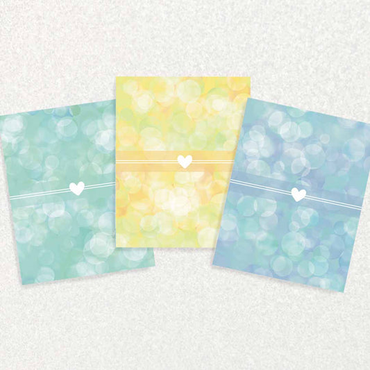 Front of New Baby Keepsake Prompt Cards set of three each has a white heart in front of different background - blue, yellow, or teal